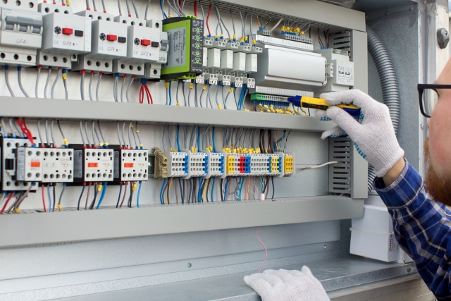 工場の配電盤を操作する手元