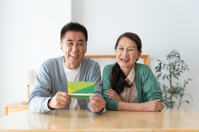 通帳を持ち笑顔の夫婦